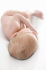Newborn baby boy lying on white background. — Stock Photo