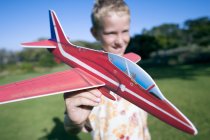 Хлопчик грає з моделлю літака в парку . — стокове фото