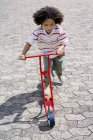 Маленький хлопчик їде поштовхом скутер . — стокове фото