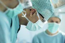 Team of surgeons performing operation in operating theater. — Stock Photo