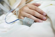 Capteur d'oxygène sanguin sur le doigt du patient en salle de soins intensifs, gros plan . — Photo de stock