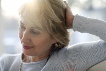 Mature woman smiling and looking away — Stock Photo