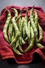 Broad beans on red cloth. — Stock Photo