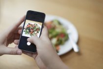 Mani femminili scattare foto di cibo con smartphone . — Foto stock