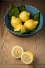 Limões na tigela na mesa, ainda vida . — Fotografia de Stock