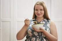 Jeune femme manger bol de salade — Photo de stock