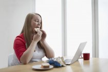 Joven mujer comiendo sándwich - foto de stock