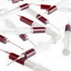 Blutproben in Spritzen auf weißem Hintergrund. — Stockfoto