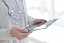 Cropped view of female doctor holding digital tablet. — Stock Photo