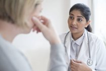 Médico feminino conversando com loira paciente adulto médio . — Fotografia de Stock