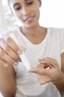 Mid adult woman doing pin prick test on finger. — Stock Photo