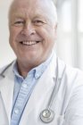 Senior male doctor smiling and looking in camera. — Stock Photo