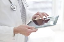 Обрезанный взгляд на женщину-врача с помощью цифрового планшета . — стоковое фото