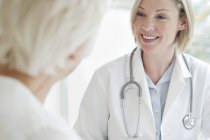 Female doctor smiling to senior patient. — Stock Photo