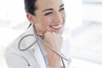 Женщина-врач держит стетоскоп и улыбается . — стоковое фото