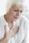 Senior woman touching chest, close-up. — Stock Photo