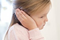 Menina idade elementar com dor de ouvido segurando orelha com palma . — Fotografia de Stock
