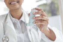 Médico femenino sosteniendo inhalador, primer plano . - foto de stock