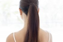 Young woman with ponytail, rear view. — Stock Photo