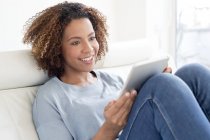 Donna che utilizza tablet digitale a casa — Foto stock