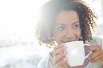 Mulher bebendo café e olhando para longe — Fotografia de Stock