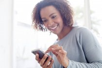Mujer atractiva usando el teléfono celular - foto de stock