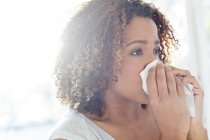 Woman blowing nose on tissue. — Stock Photo