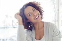 Woman with curly hair smiling at camera — Stock Photo
