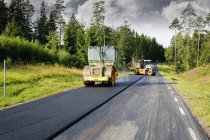 Two steamrolls asphalting road — Stock Photo