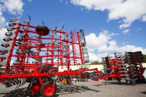 Machines rouges avec charrues convertibles à la ferme . — Photo de stock