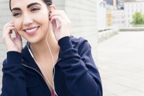 Jeune femme portant des écouteurs et souriant . — Photo de stock