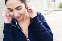 Young woman wearing earphones and smiling. — Stock Photo