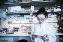 Cientista feminina trabalhando em laboratório com tablet digital . — Fotografia de Stock
