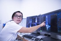 Radiologista do hospital apontando para tomografias computadorizadas . — Fotografia de Stock