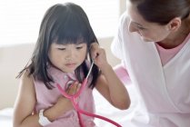 Asiatico ragazza utilizzando stetoscopio con infermiera . — Foto stock