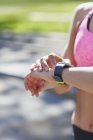 Donna che controlla il tempo sullo smartwatch sportivo . — Foto stock