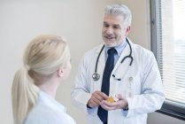 Mature doctor talking to female patient. — Stock Photo