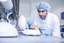Ученый-мужчина в защитной одежде работает в лаборатории . — стоковое фото