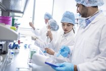 Scienziati in indumenti protettivi che lavorano in laboratorio . — Foto stock