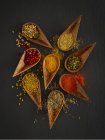 Dried spices in wooden spoons, overhead view. — Stock Photo