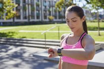 Donna che controlla il tempo sullo smartwatch sportivo . — Foto stock