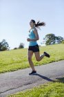 Jeune femme jogging sur le chemin du parc . — Photo de stock
