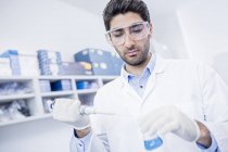 Male laboratory assistant using pipette. — Stock Photo