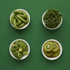 Produtos frescos em pratos sobre fundo verde . — Fotografia de Stock