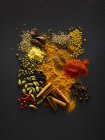 Dried spices on black slate, overhead view. — Stock Photo