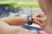 Frau kontrolliert Zeit auf Sport-Smartwatch. — Stockfoto