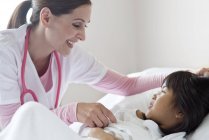 Girl in hospital bed talking to female nurse. — Stock Photo