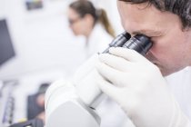 Cientista masculino usando microscópio . — Fotografia de Stock