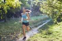 Young woman jogging on park path. — Stock Photo