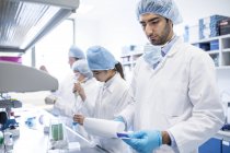 Scienziati in indumenti protettivi che lavorano in laboratorio . — Foto stock